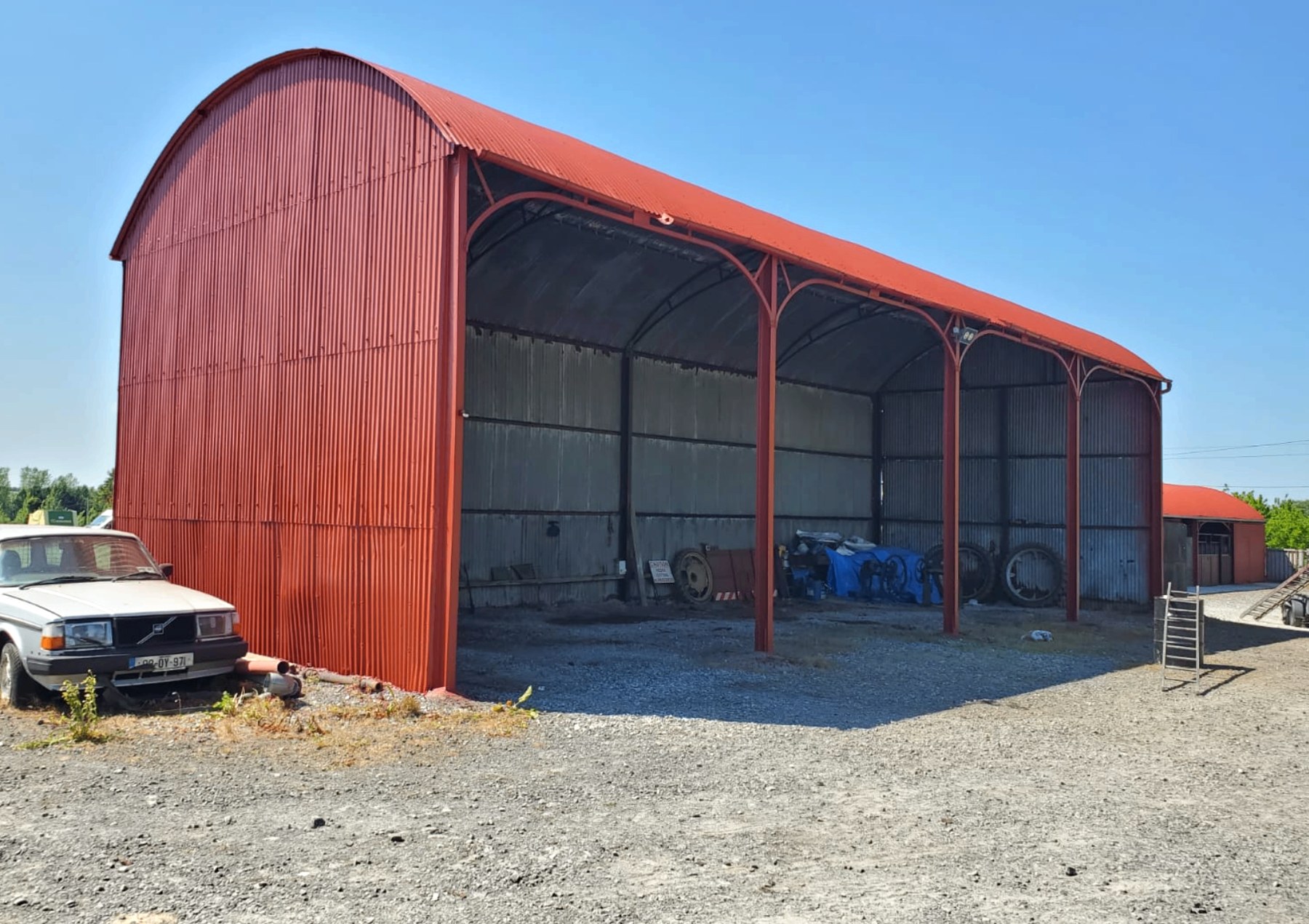 Finished red curved-roof machinery shed with open bay
